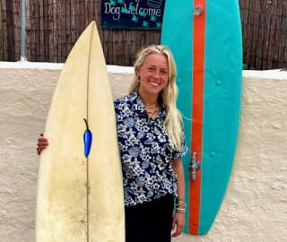 Female with surfboard at wash station